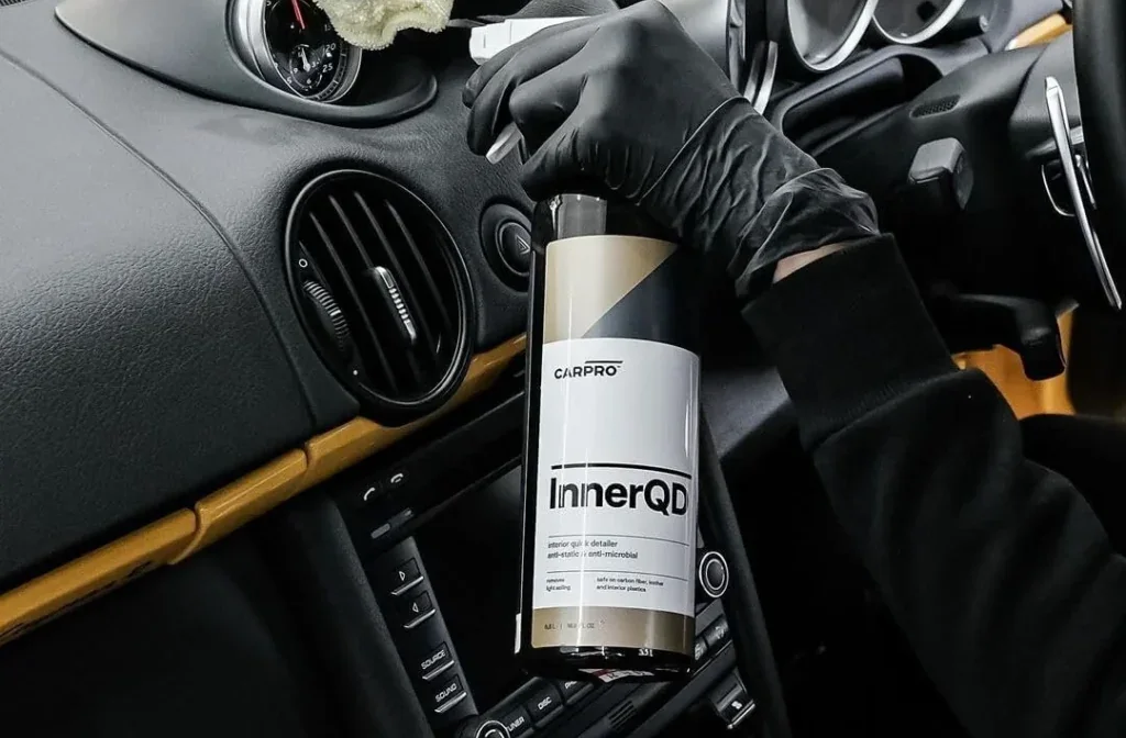 Detailer cleaning a dashboard and console